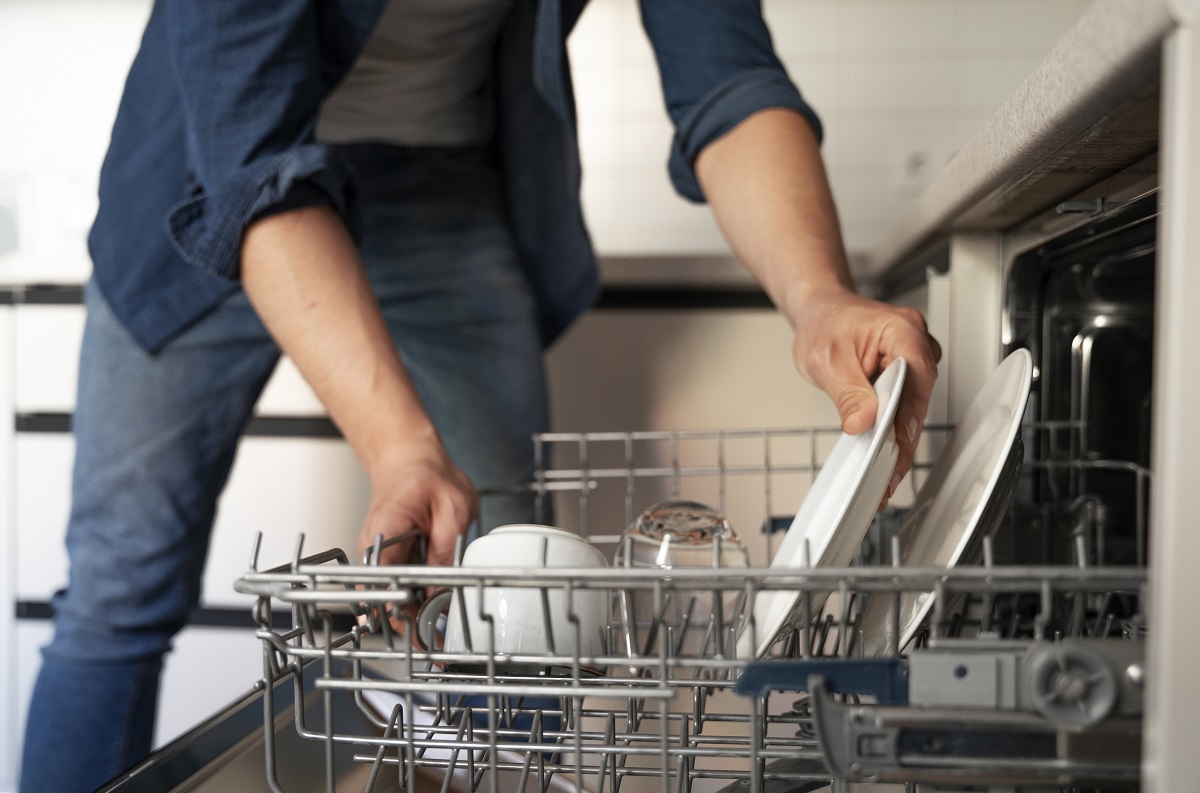 man putting dishes into a dishwasher